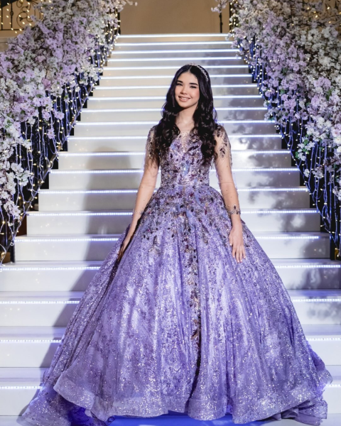 Debutante em vestido lilás brilhante em escadaria iluminada