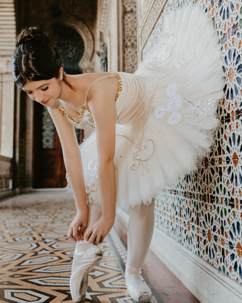 Bailarina com tutu branco em cenário clássico